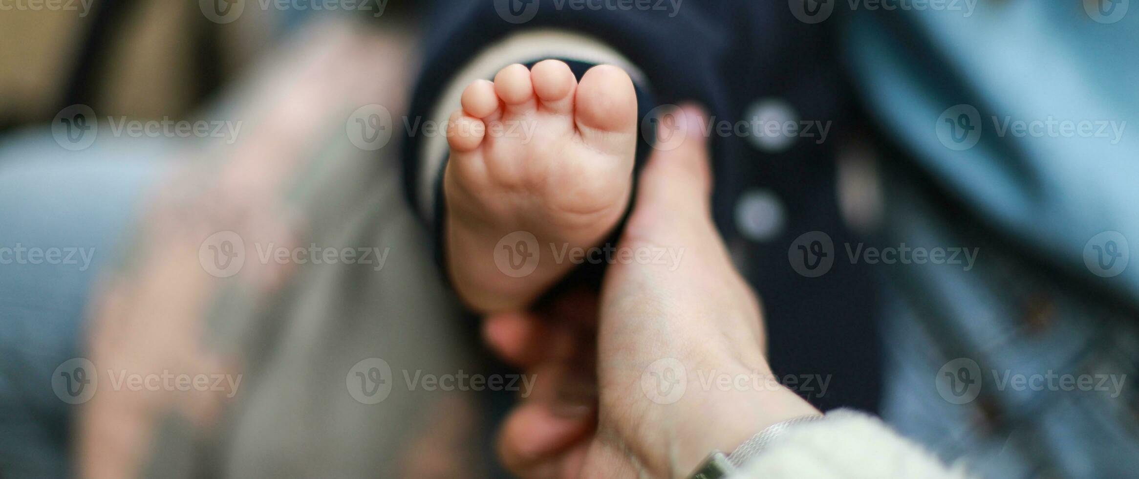 bannière peu bébé pied. le main détient le enfant est jambe. les enfants protection journée photo