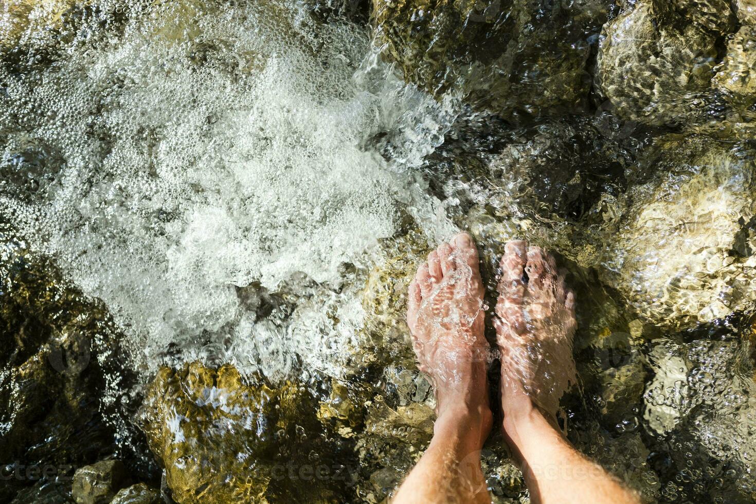 homme pieds permanent sur pierre dans une ruisseau photo