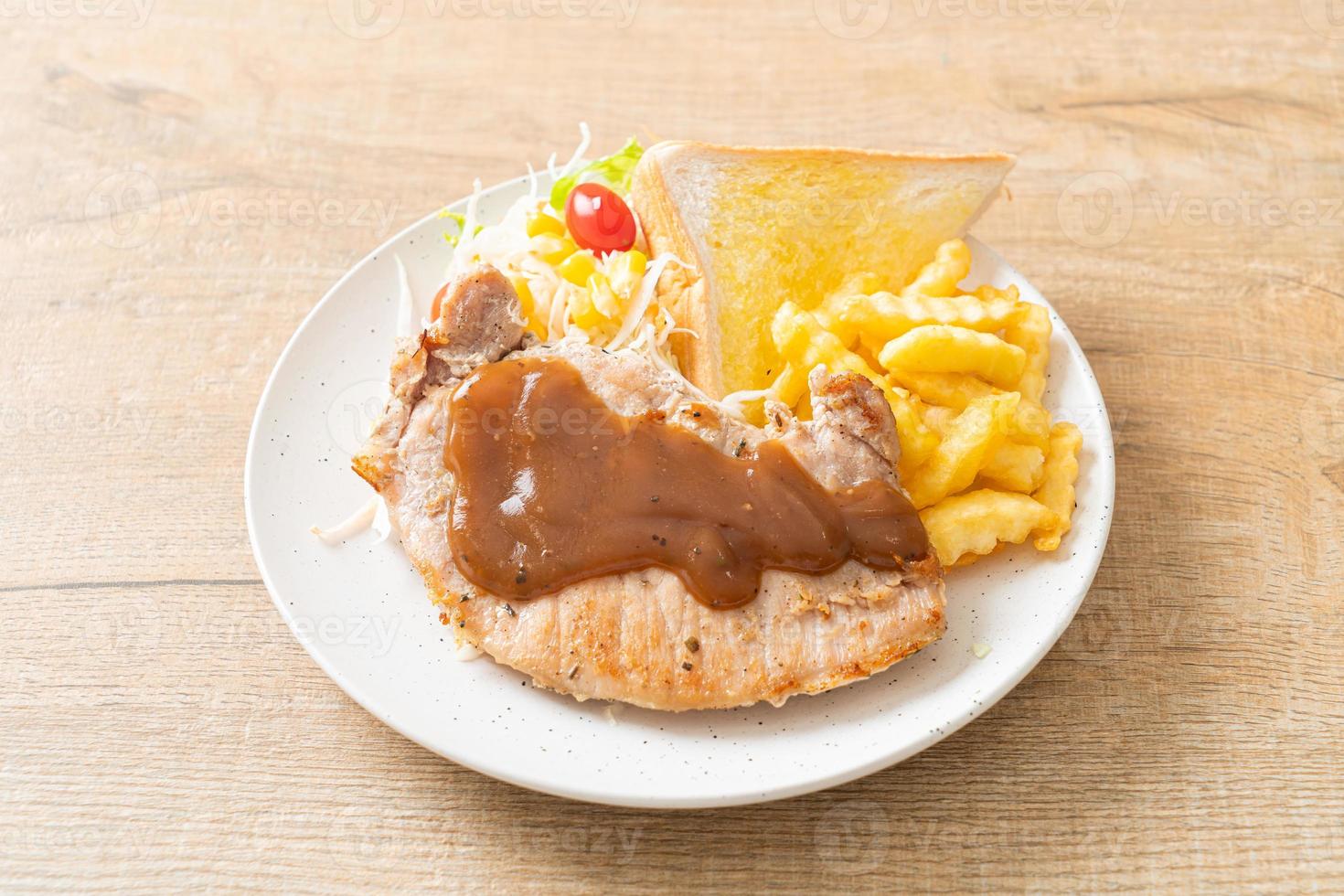 steak de porc avec sauce au poivre noir et mini salade photo