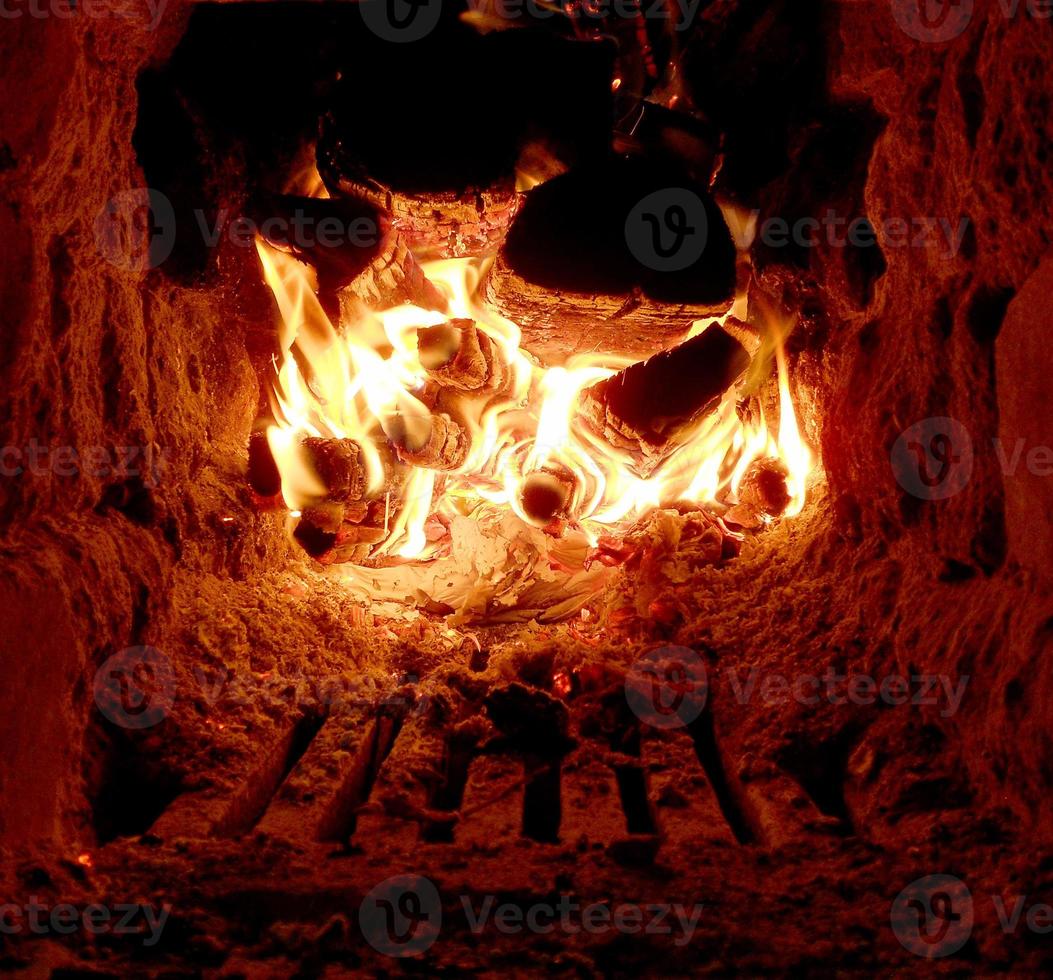 feu rouge de tranche de bois, charbons noirs gris foncé à l'intérieur d'un brasero en métal photo