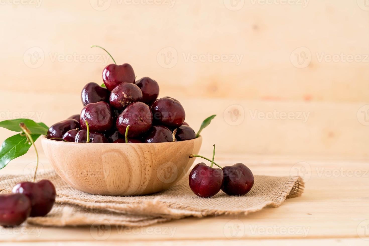 cerise fraîche dans un bol en bois sur la table photo