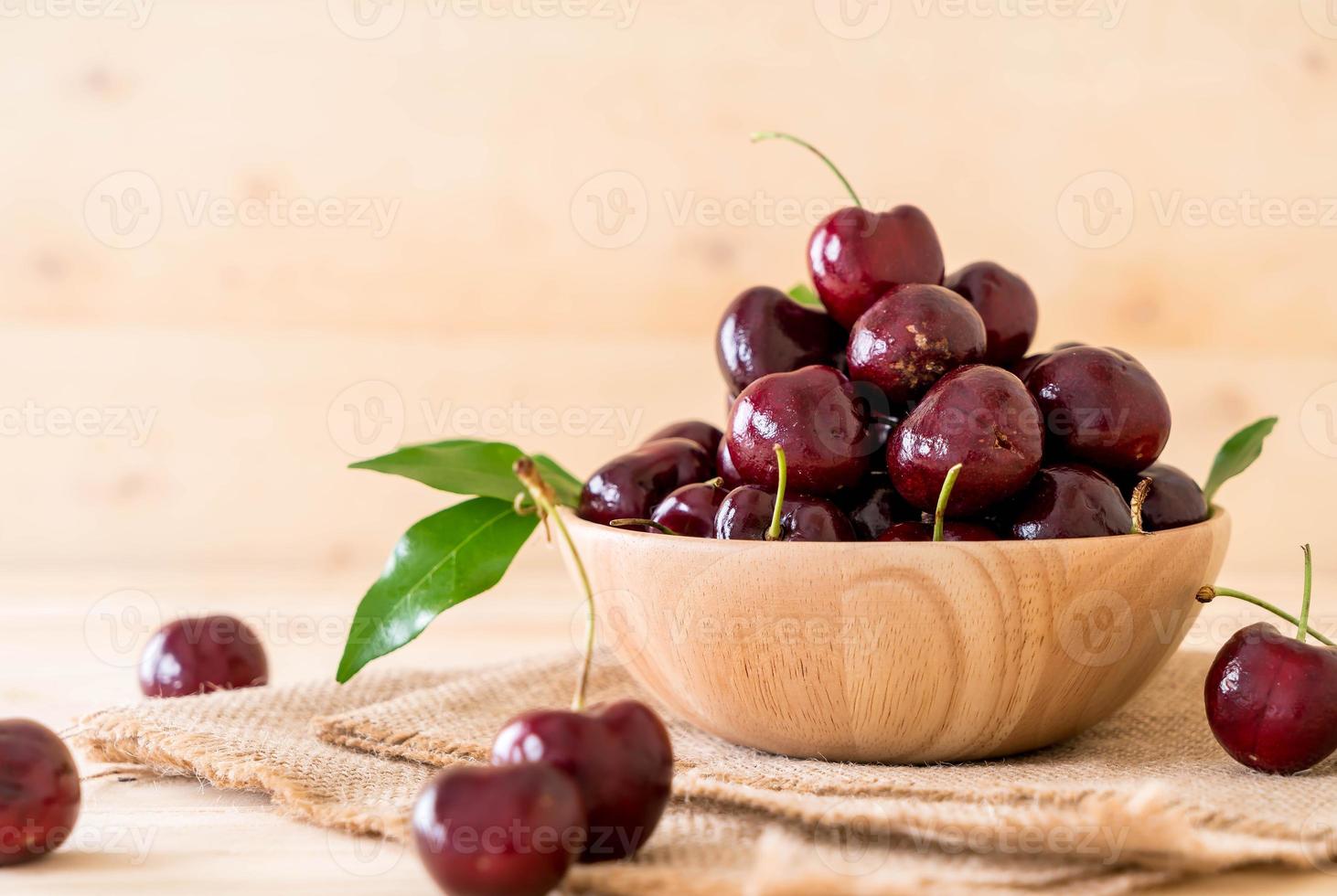 cerise fraîche dans un bol en bois sur la table photo