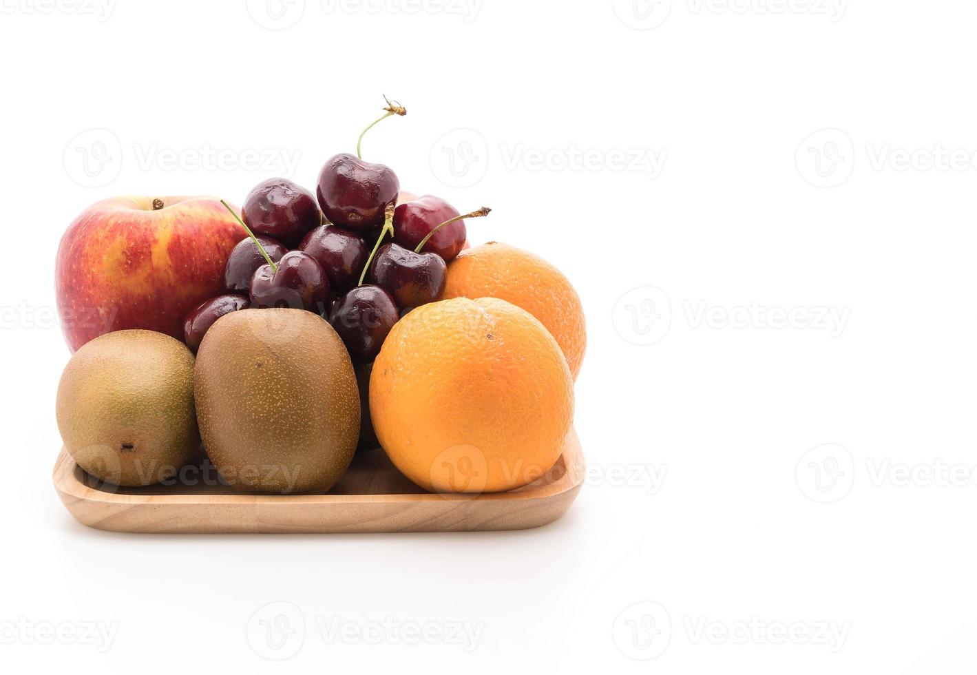 Fruits mélangés en plaque de bois sur fond blanc photo