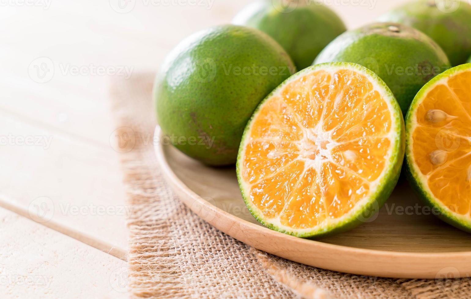 orange fraîche sur plaque de bois sur la table photo