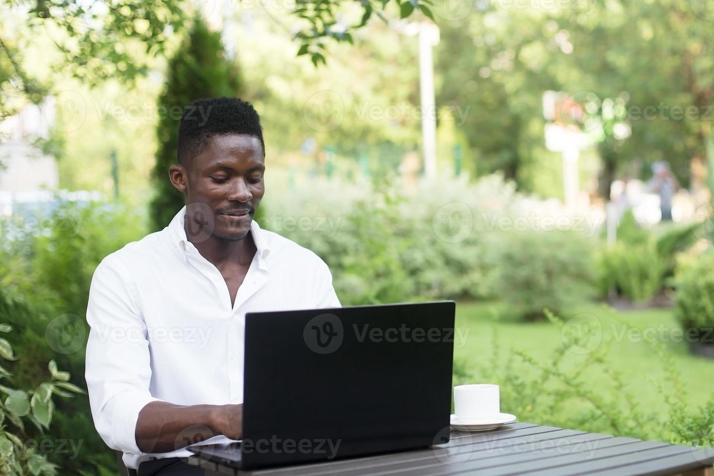 homme d'affaires afro-américain, travaille sur un ordinateur portable dans un café, pigiste photo