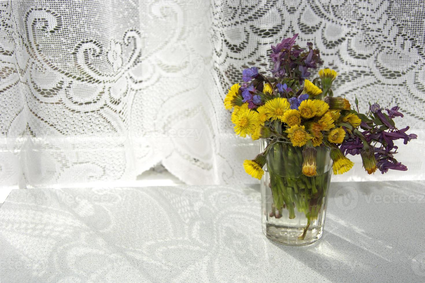 un bouquet de fleurs sauvages dans un vase sur la table tôt le matin photo