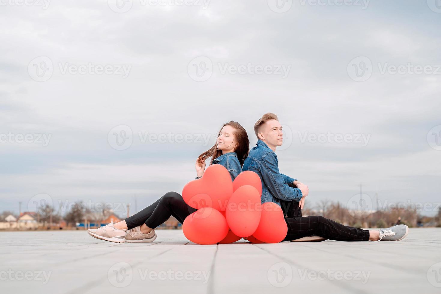 couple assis tenant un tas de ballons rouges passer du temps ensemble photo