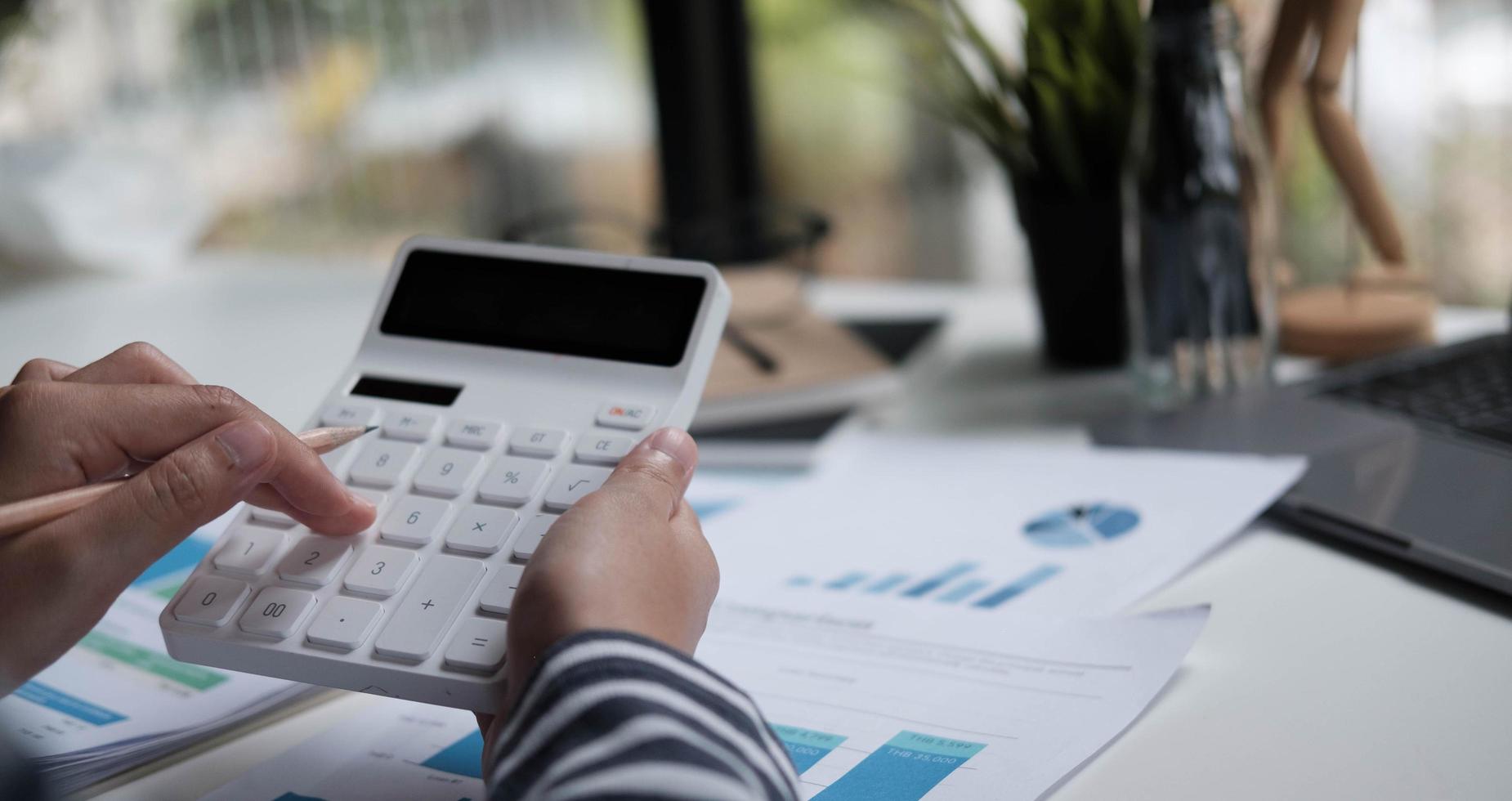 gros plan femme budget de planification, à l'aide d'une calculatrice et d'un ordinateur portable photo