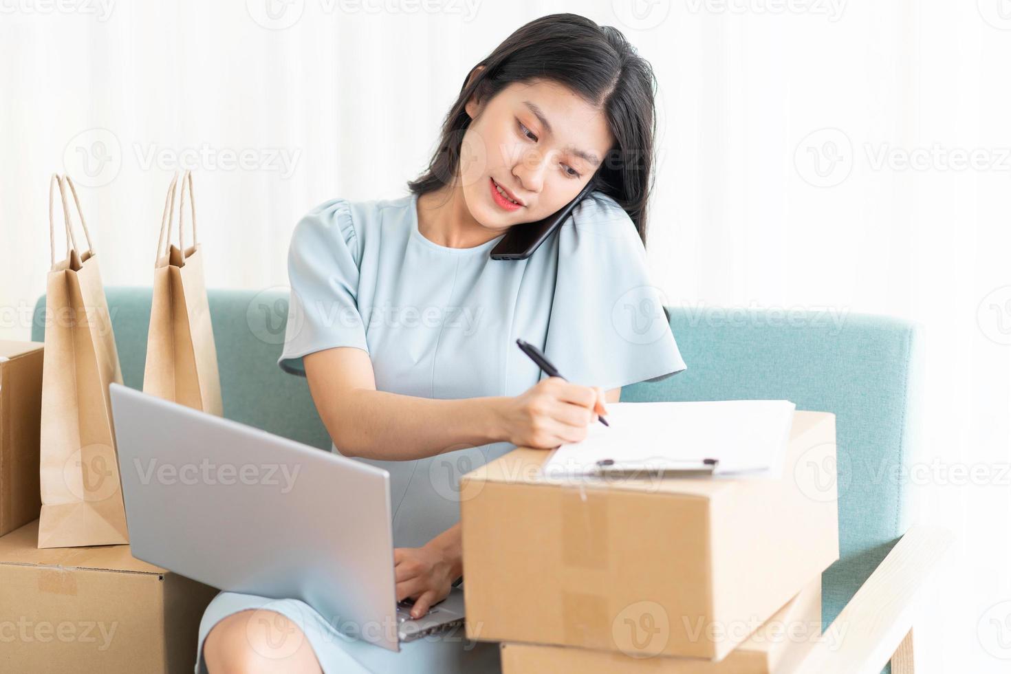 jeune fille asiatique assise à la maison vendant en ligne photo