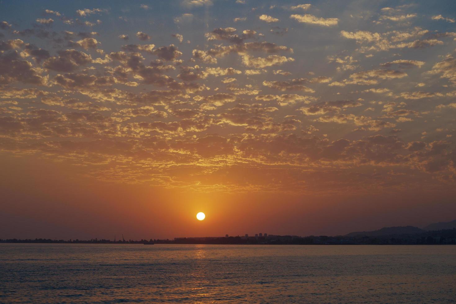 coucher de soleil lumineux sur une mer calme et un ciel coloré photo