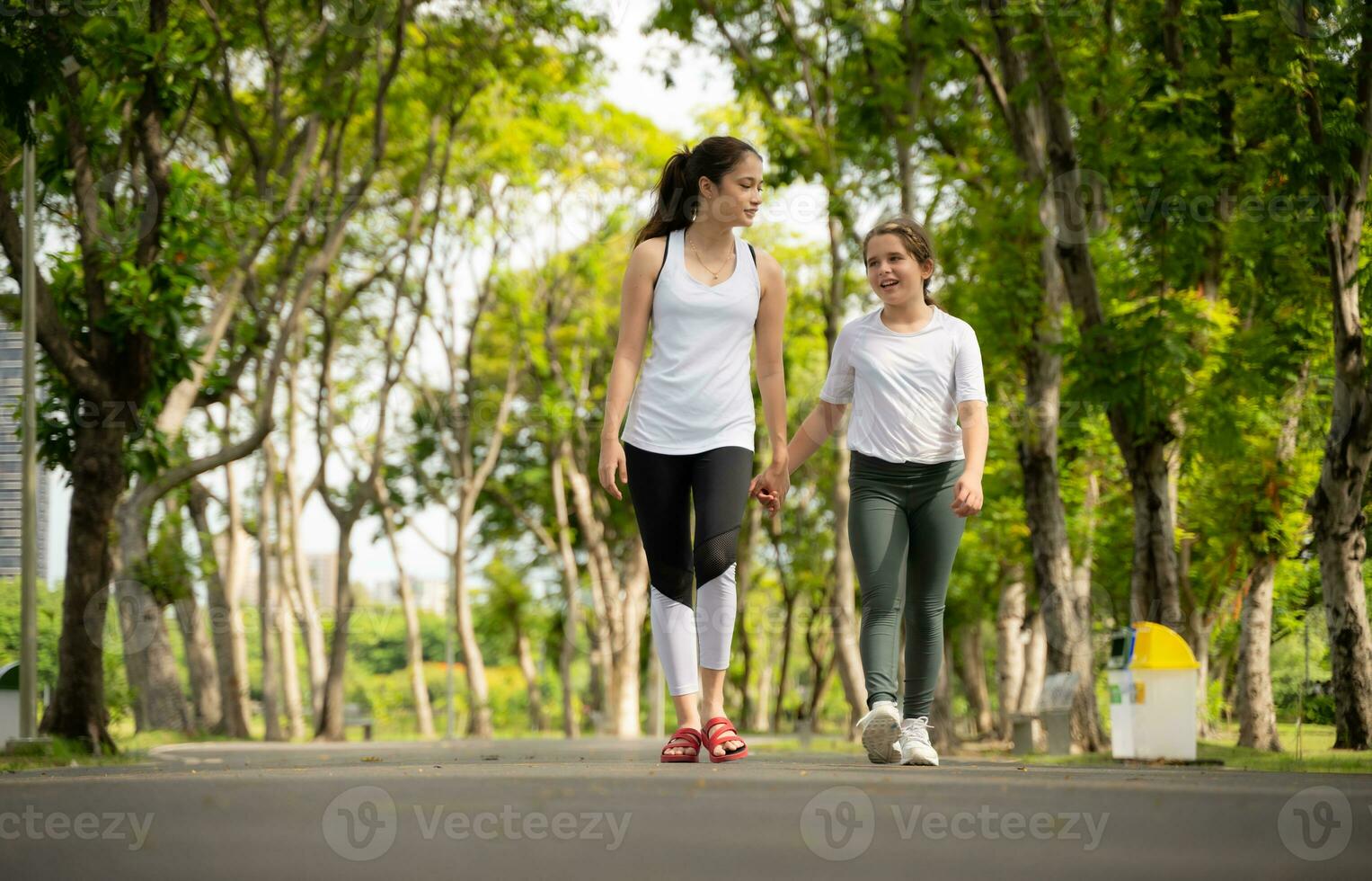 Jeune femelle et peu fille avec en marchant des exercices dans le ville parc photo