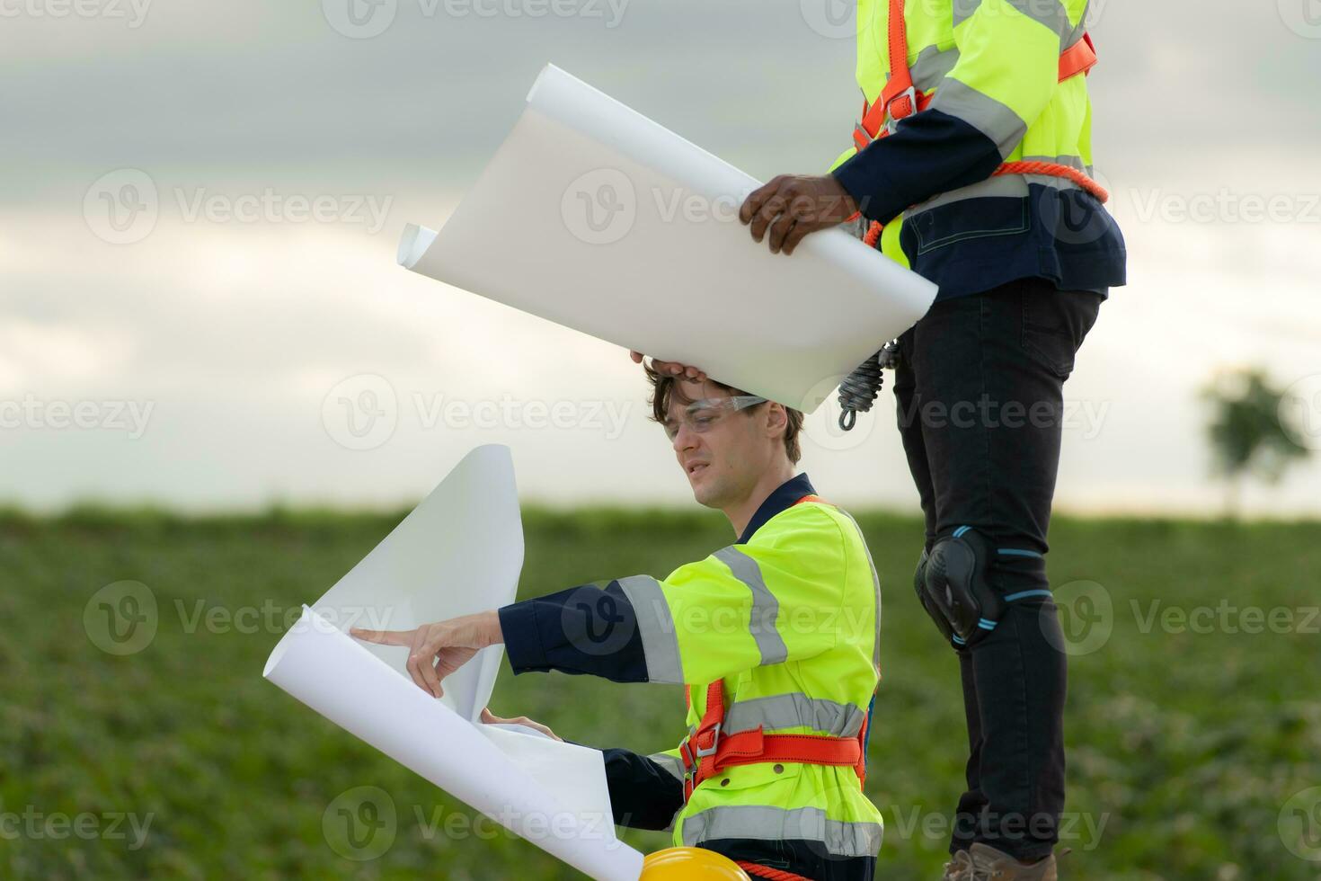 ingénieurs et techniciens travail ensemble sur le la tour base de une grand vent turbine avec une vent turbine champ dans le arrière-plan, le concept de Naturel énergie de vent. photo