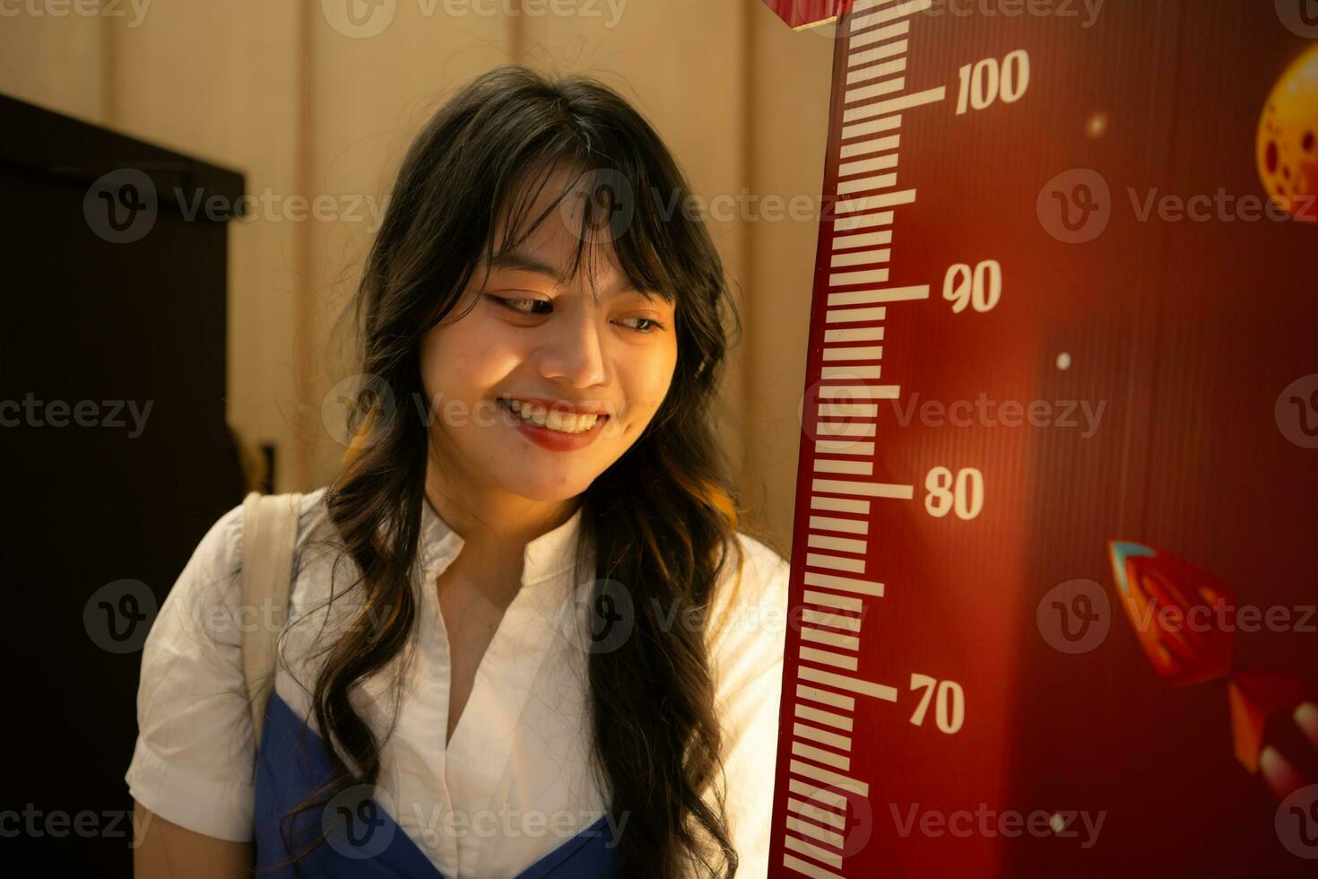 portrait de un asiatique femme avec la taille des mesures à Payer pour enfant des billets à regarder films dans le cinéma photo