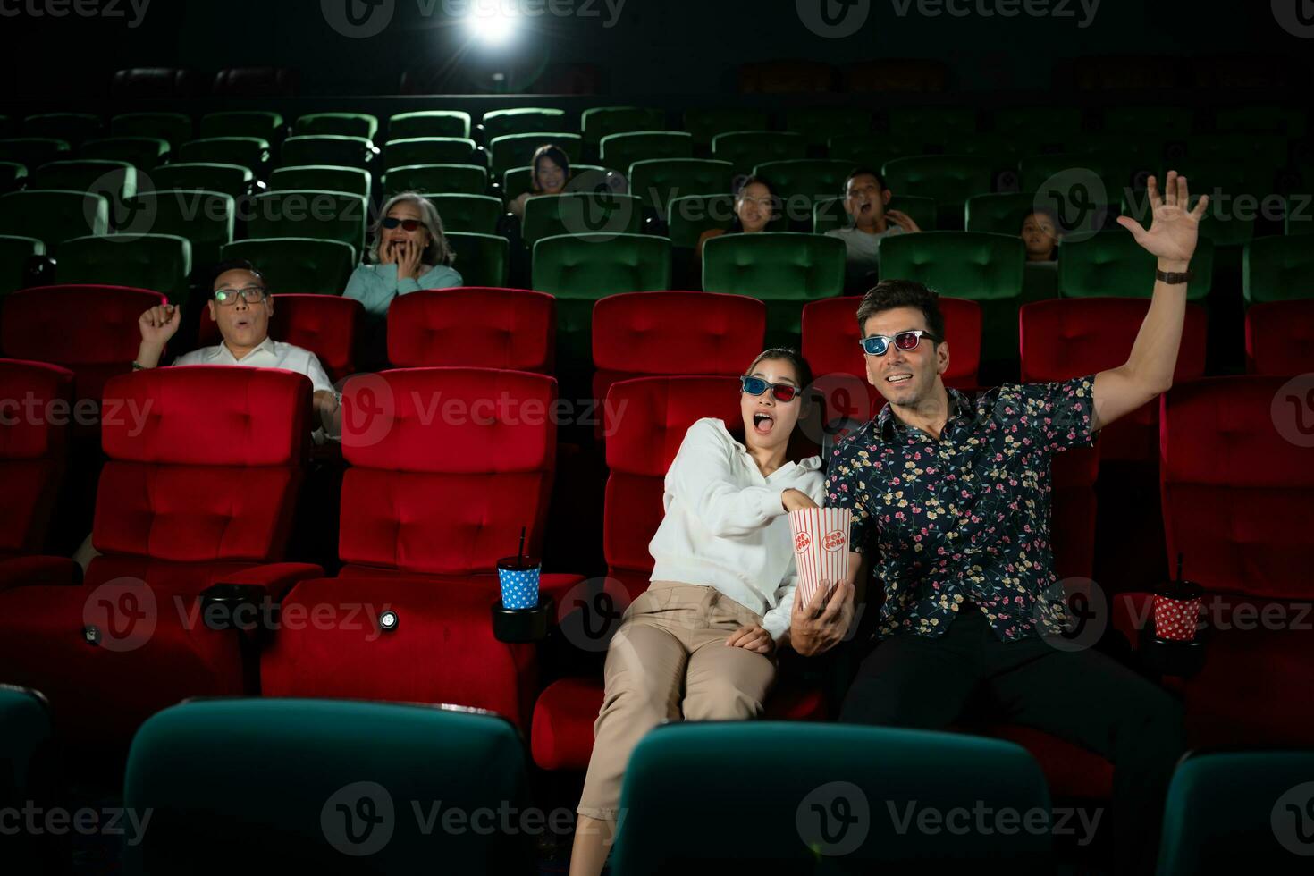 dans une cinéma, une Jeune couple paire portant 3d des lunettes montres films et mange Popcorn. photo