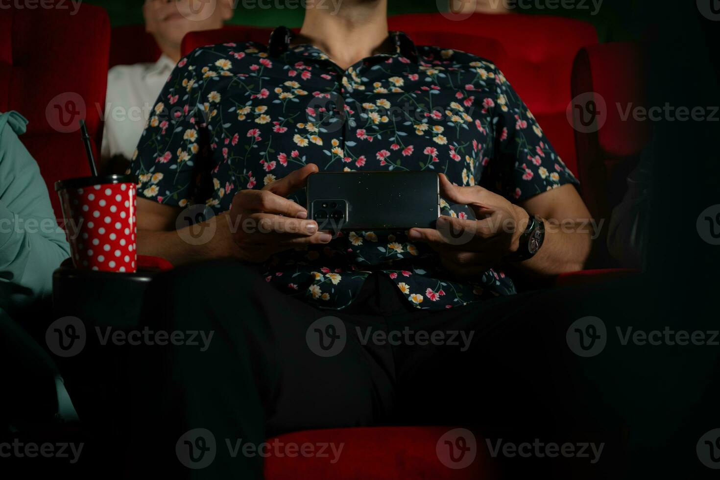 une Jeune homme a été secrètement enregistrement une film dans une film théâtre tandis que en train de regarder une film photo