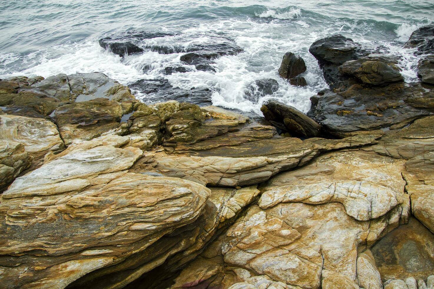 une rocheux littoral avec vagues s'écraser contre le rochers photo