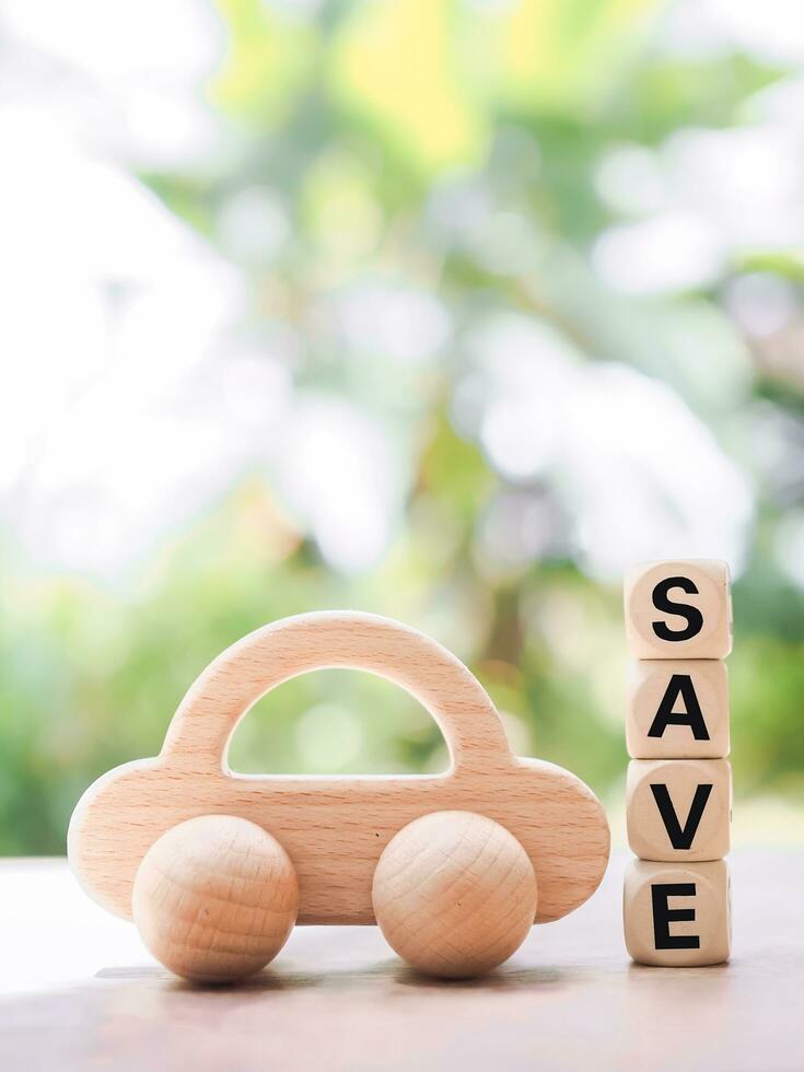 en bois jouet voiture et en bois blocs avec le mot sauvegarder. le concept de économie argent acheter une voiture dans le avenir. photo