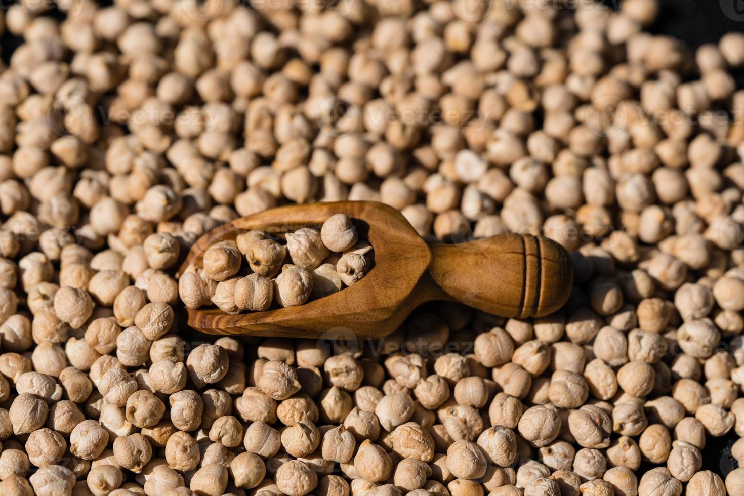 un tas de pois chiches et une cuillère en bois photo