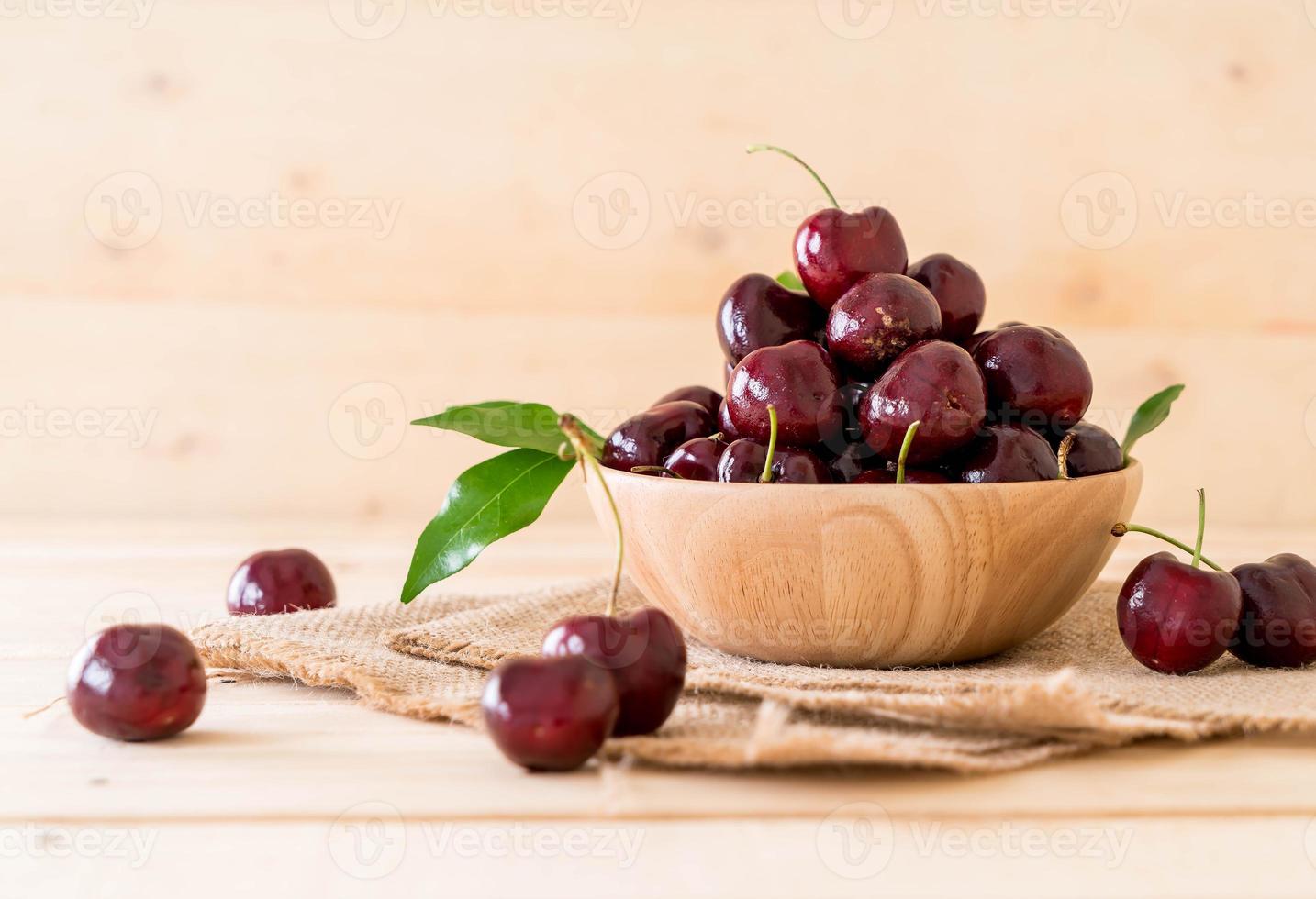 cerise fraîche dans un bol en bois sur la table photo