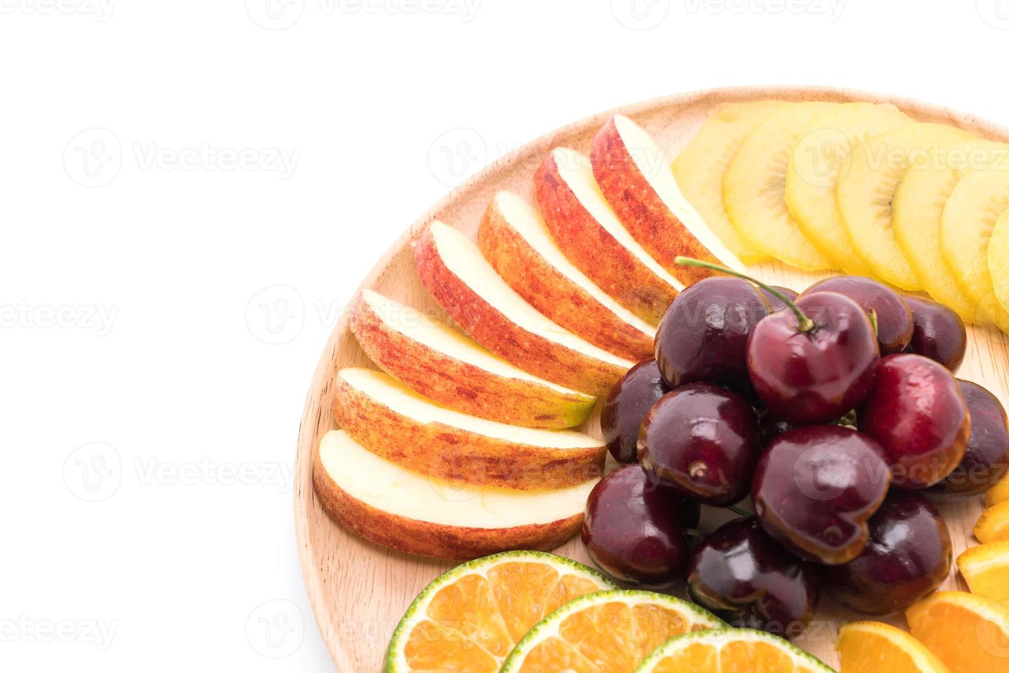 Fruits tranchés mélangés en plaque de bois photo