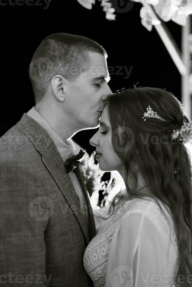 la mariée et jeune marié contre le toile de fond de un soir mariage cambre photo