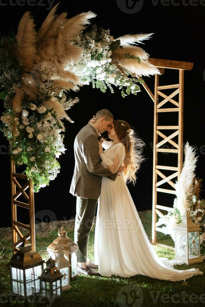 la mariée et jeune marié contre le toile de fond de un soir mariage cambre photo