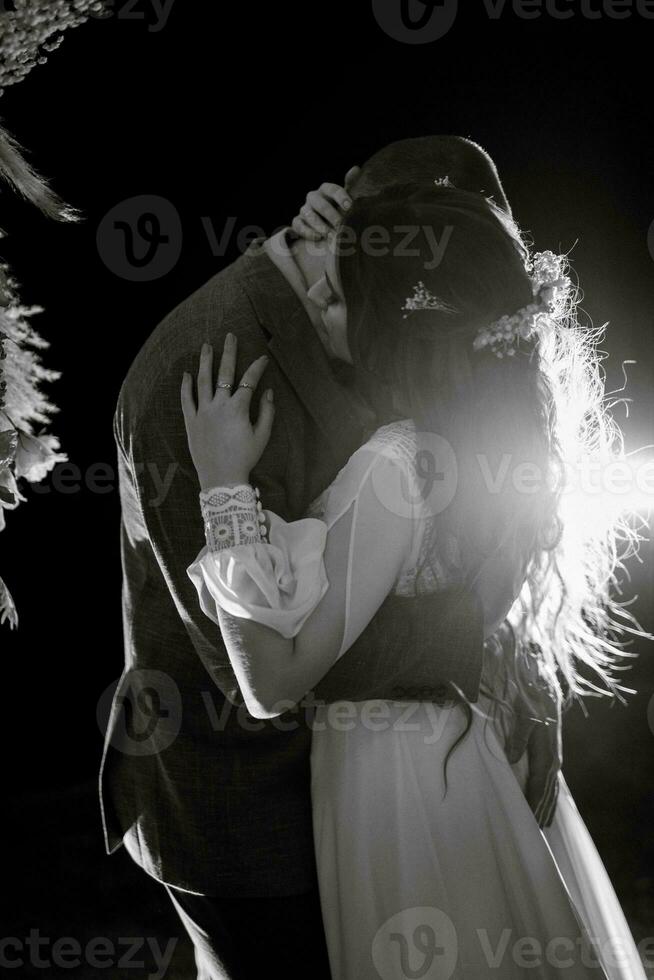 la mariée et jeune marié contre le toile de fond de un soir mariage cambre photo