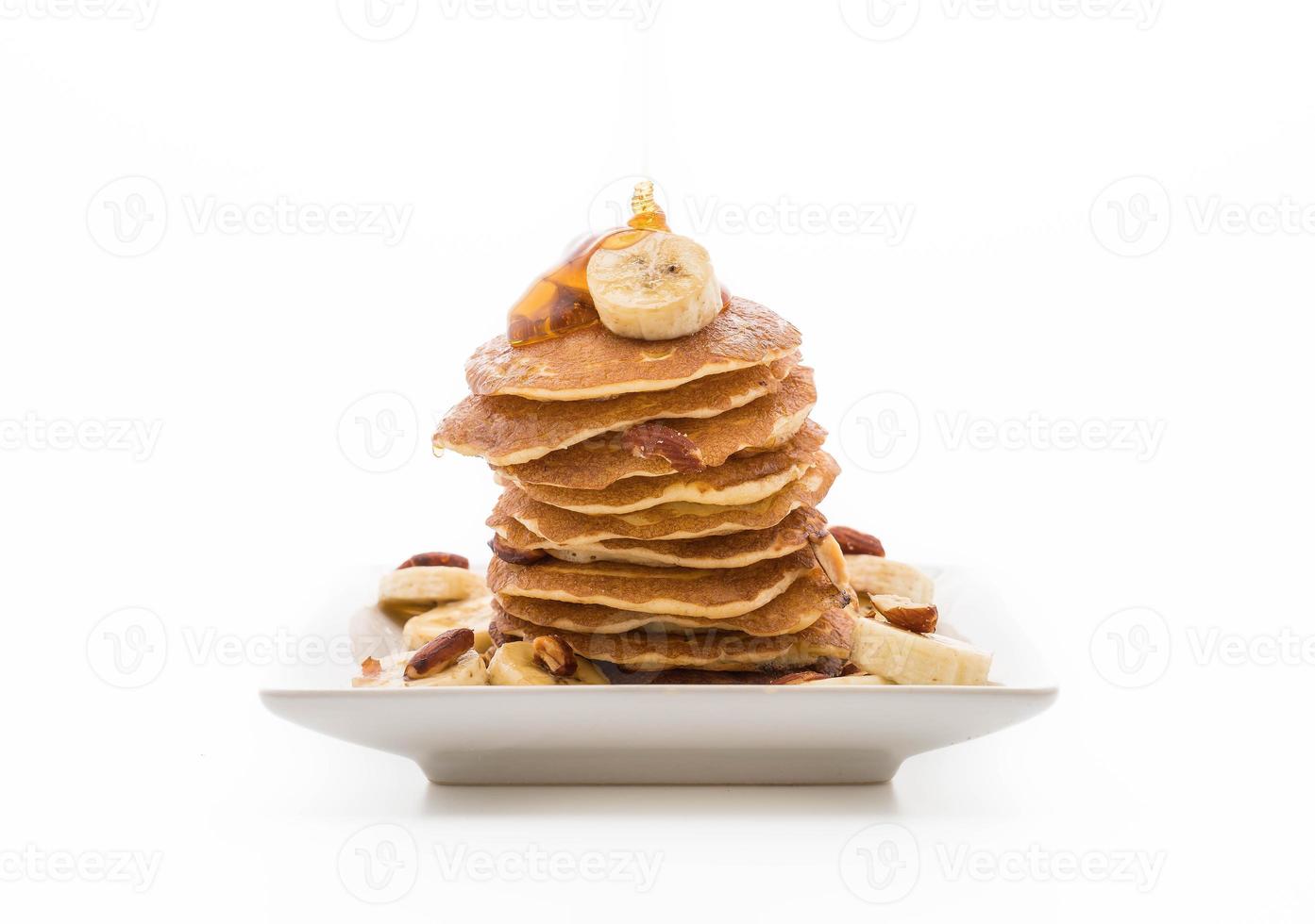 Crêpe aux bananes et aux amandes avec du miel sur fond blanc photo