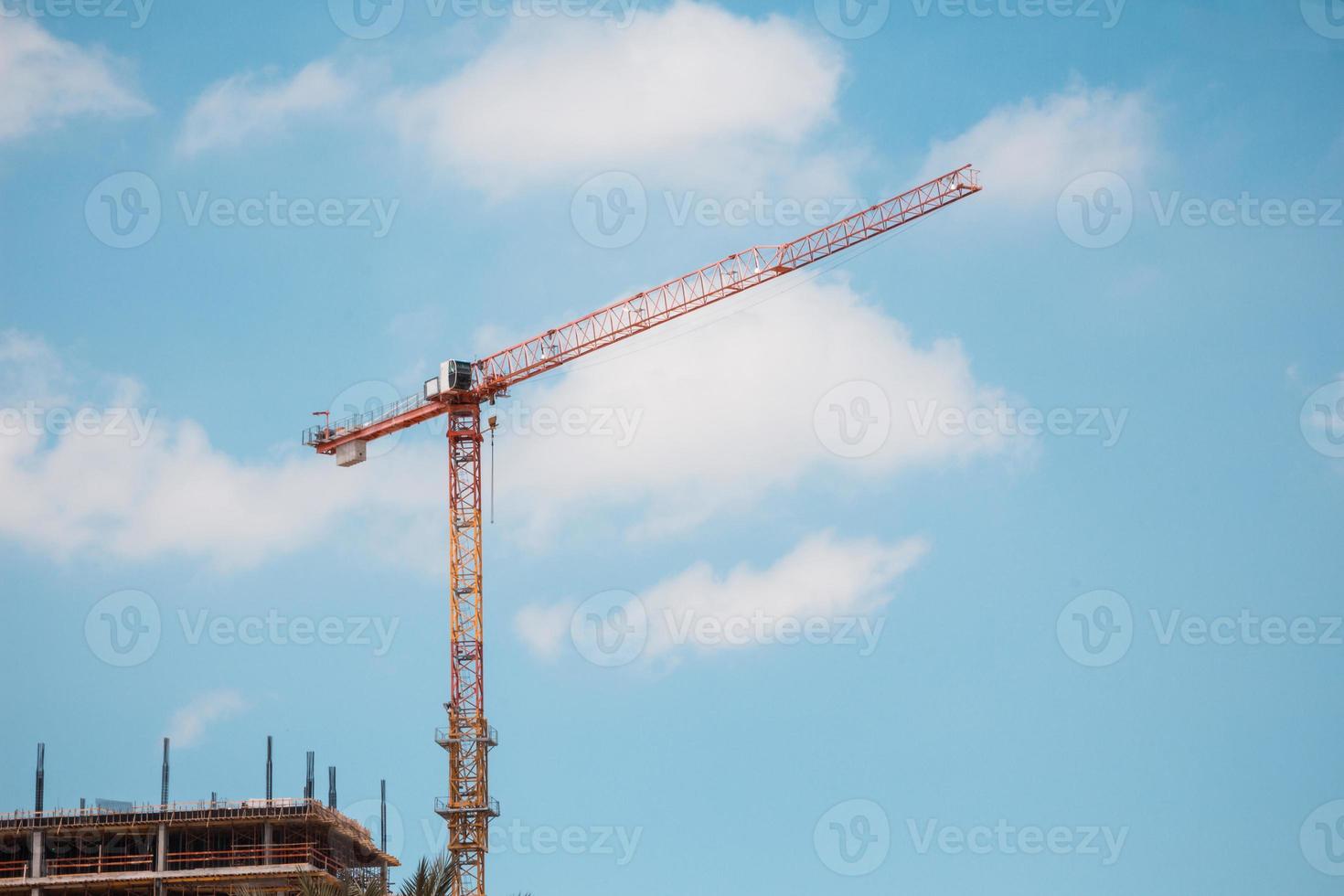 Grue à tour en chantier sur ciel bleu avec des nuages photo