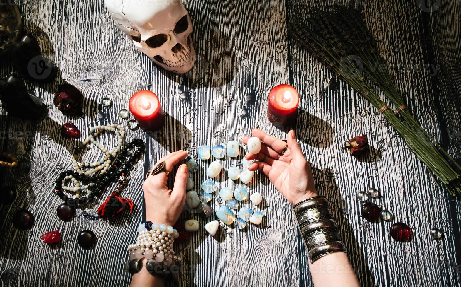 les mains du diseur de bonne aventure avec des runes de pierre, des symboles occultes. photo