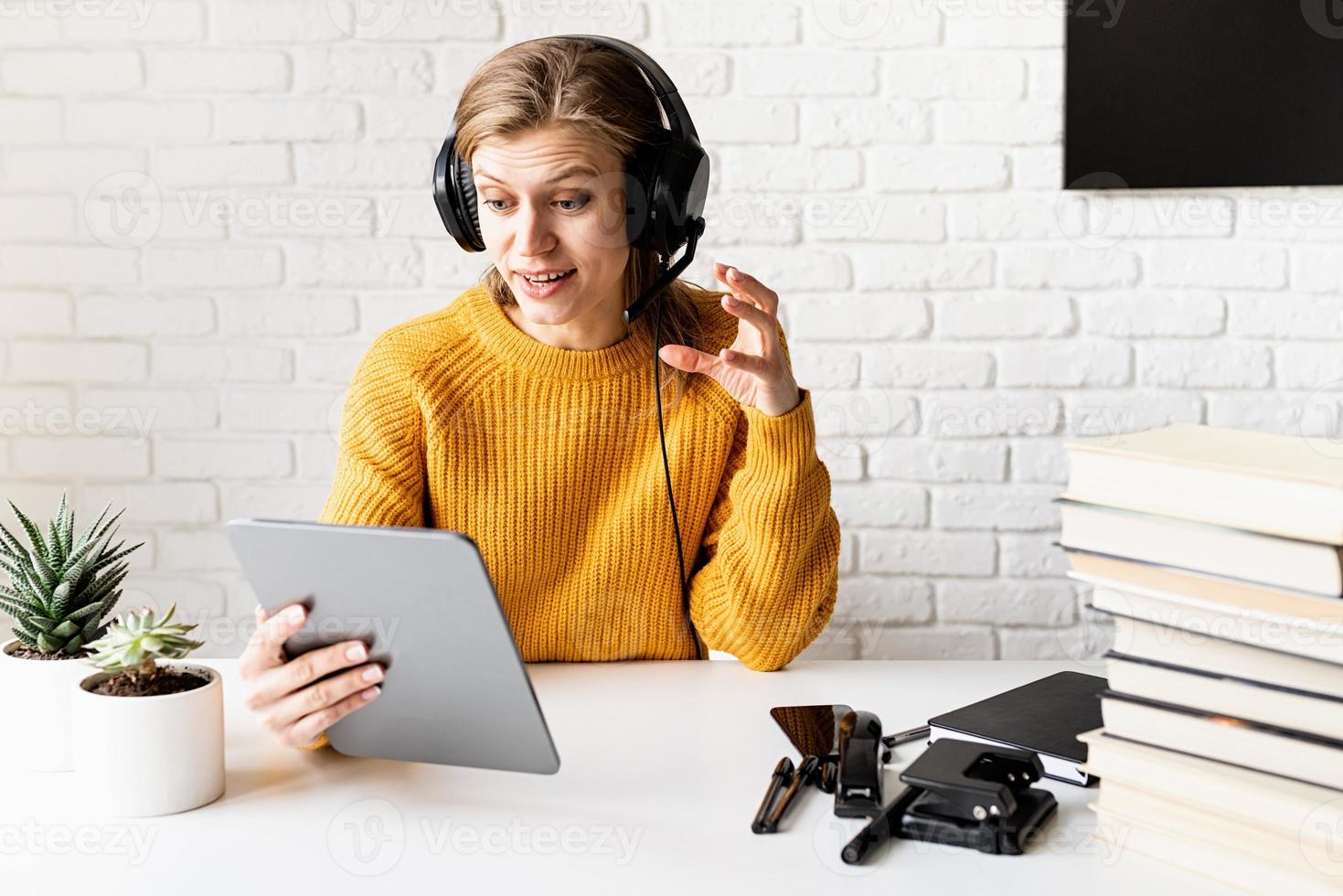 femme au casque noir étudiant en ligne à l'aide d'une tablette numérique photo