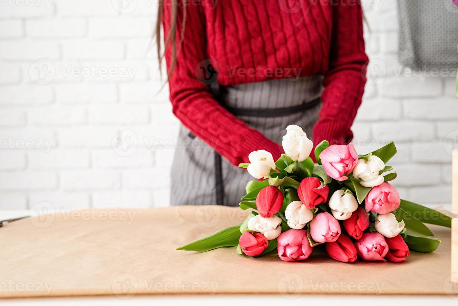 Fleuriste femme faisant un bouquet de tulipes colorées fraîches photo