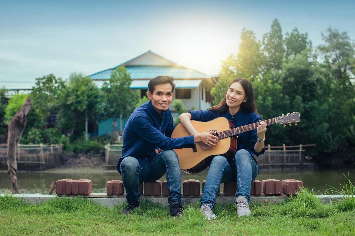 couple de famille jouant de la guitare dans le jardin à la maison photo