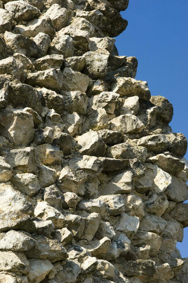 une pierre mur avec une grand oiseau sur il photo