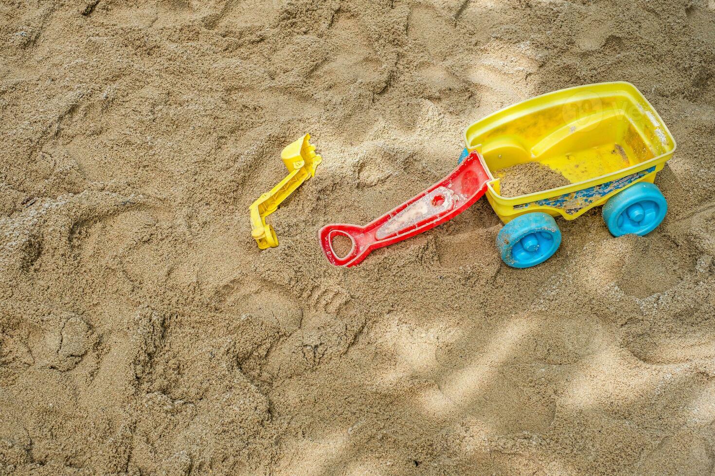 plat allonger de une plage jouet trousse propager en dehors sur le sablonneux surface de un Extérieur Cour de récréation. photo