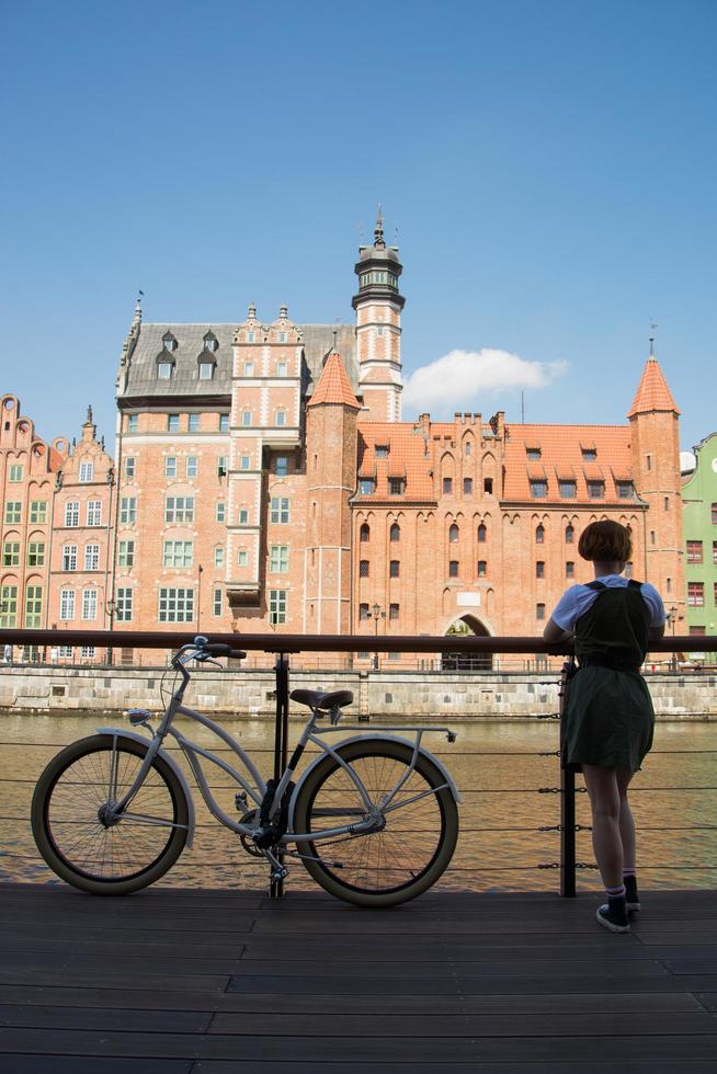 Jeune femme à vélo à la rivière à gdansk photo