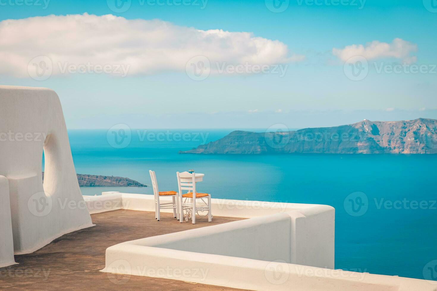 deux chaises sur la terrasse avec vue sur la mer. île de santorin, grèce. fond de voyage et de vacances. meilleur paysage de voyage pour un couple romantique ou une destination de lune de miel. emplacement et vue fantastiques photo