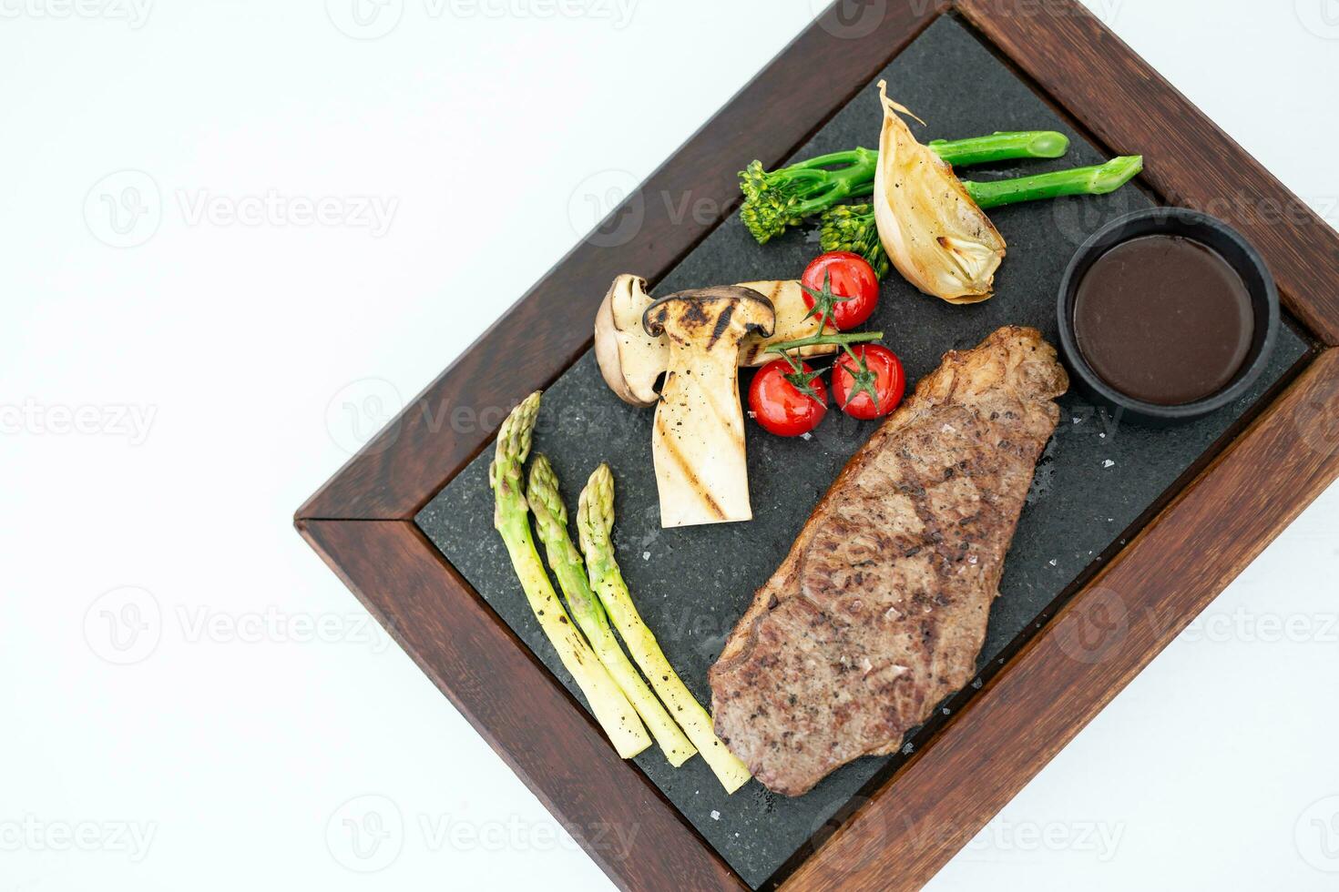 un barbecue steak dans luxe restaurant sur blanc compteur Haut voir. barbecue grillé du boeuf steak Viande avec Frais tomates, asperges, champignon tranches. en bonne santé aliments. barbecue steak dîner, gourmet cuisine photo