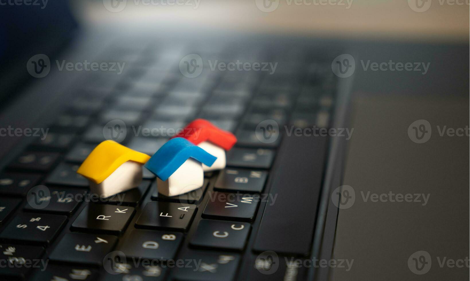 coloré Maisons sur une portable clavier. électronique les registres, utilitaires. agent immobilier prestations de service. achat et vente. des offres sur réel biens marché. bâtiment conception. photo