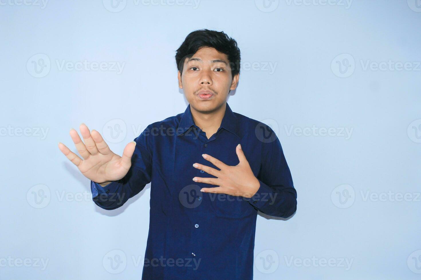 Jeune asiatique homme est relaxant de cœur attaque douleur Faire inhaler et exhalant visage expression et geste portant marine chemise photo