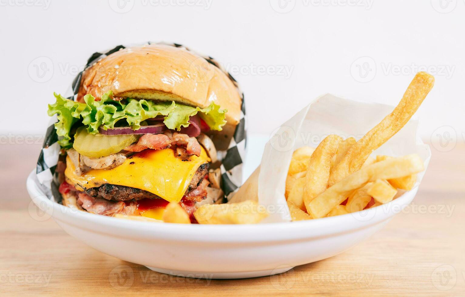 cheeseburger avec frites sur en bois tableau. proche en haut de une délicieux Hamburger avec français frites sur en bois table avec copie espace photo