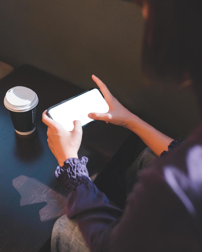 jeune femme utilisant un smartphone avec une maquette d'écran vierge photo