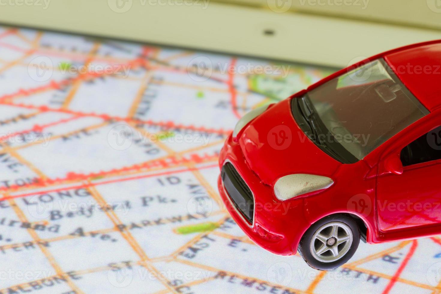Photo horizontale de jouet voiture rouge gros plan sur la carte dans l'écran de la tablette