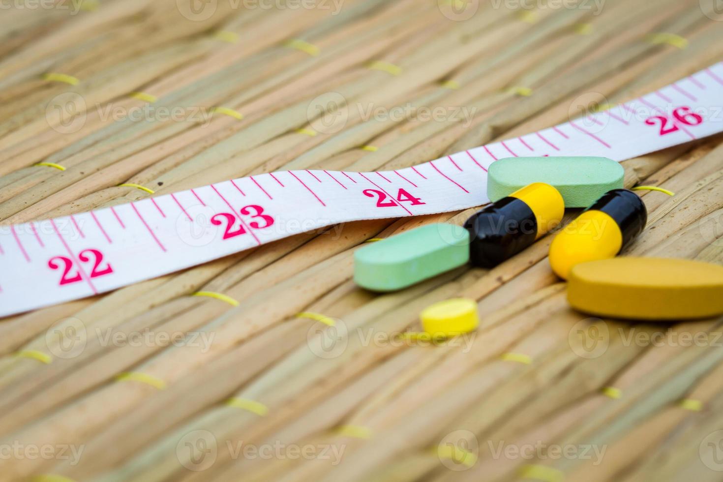 pilules et ruban à mesurer sur tapis traditionnel. photo