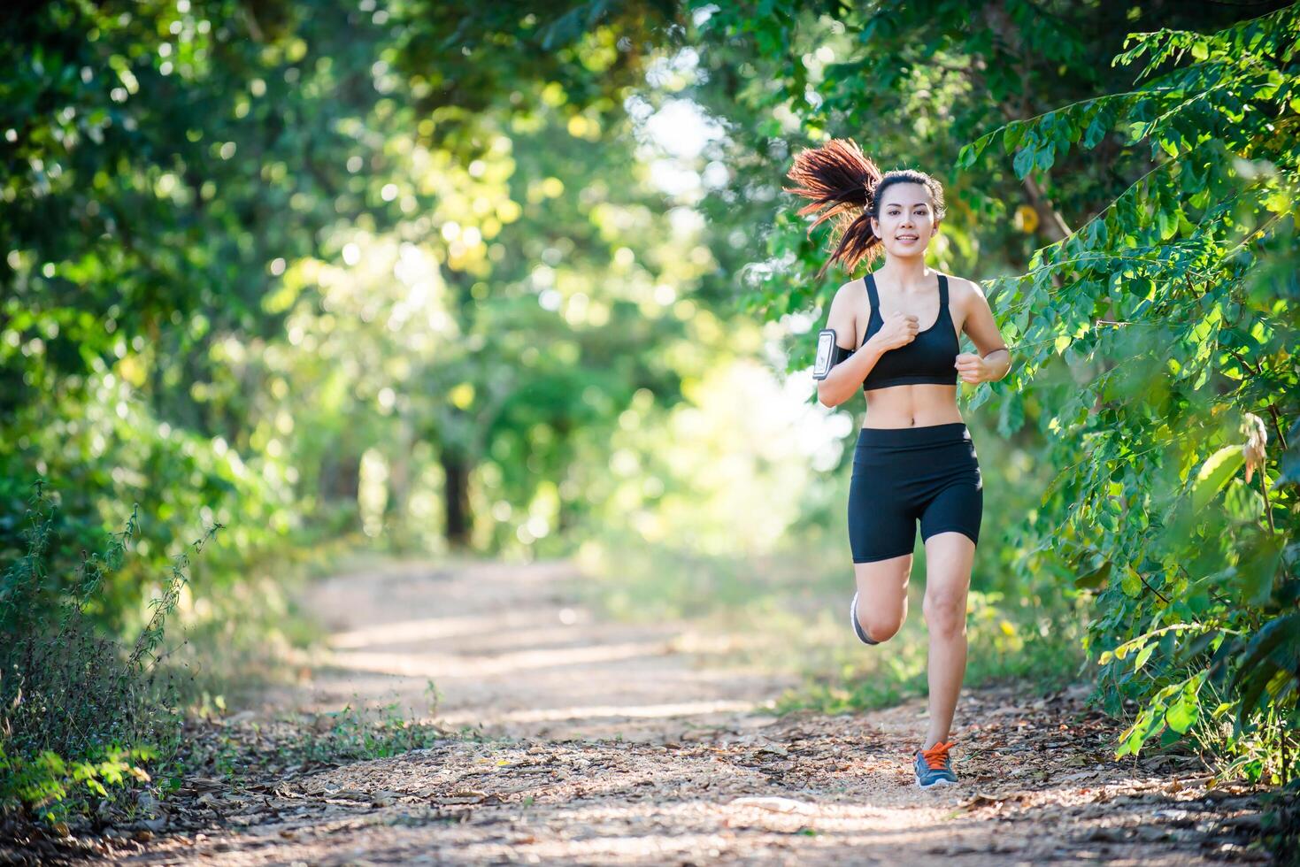 jeune femme de remise en forme qui court sur une route rurale. femme sportive en cours d'exécution. photo