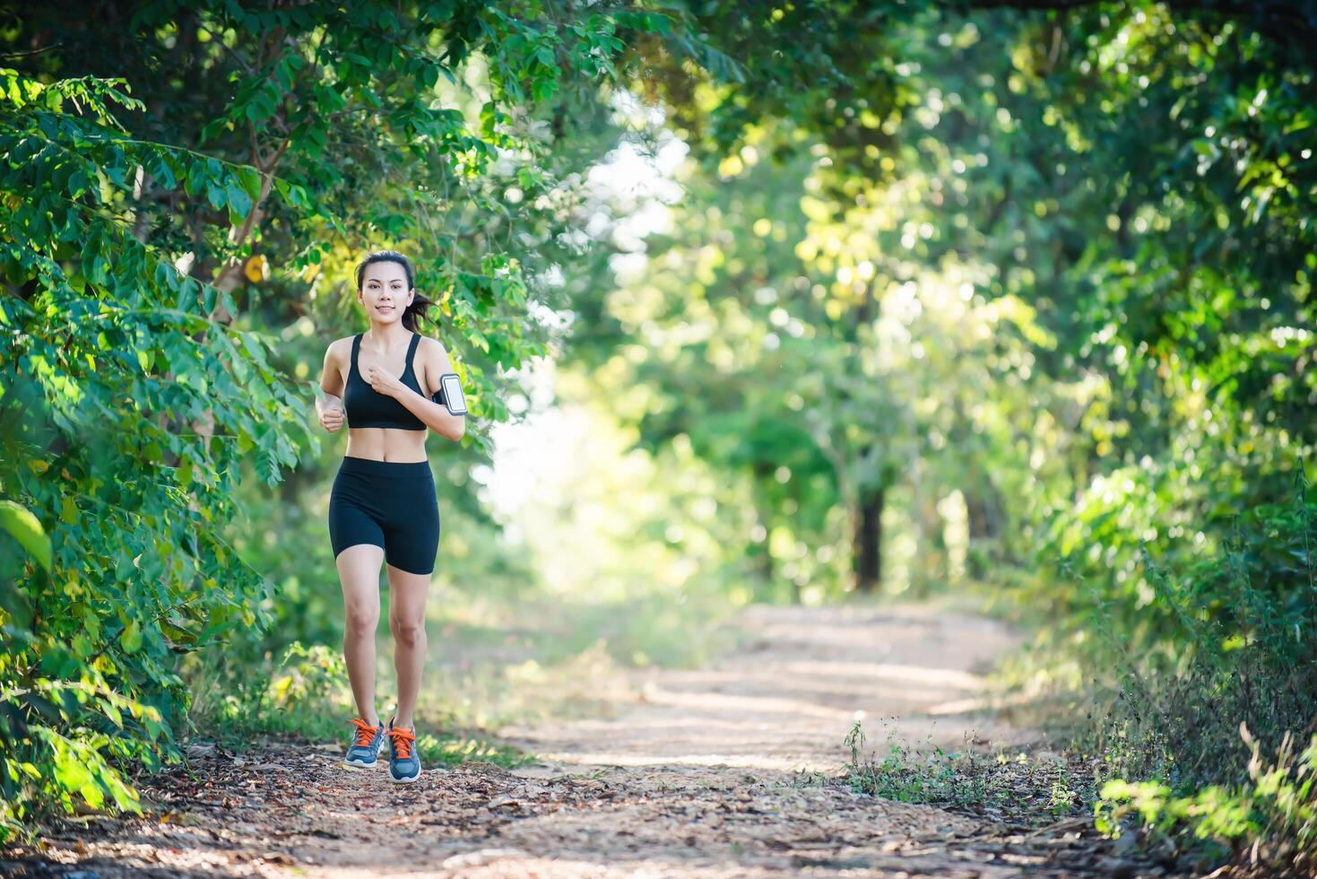 jeune femme de remise en forme qui court sur une route rurale. femme sportive en cours d'exécution. photo