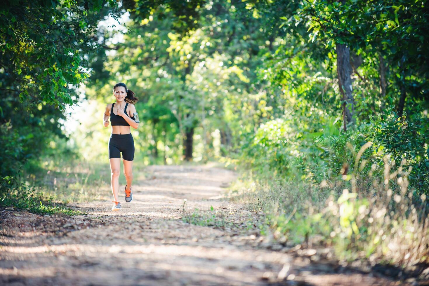 jeune femme de remise en forme qui court sur une route rurale. femme sportive en cours d'exécution. photo