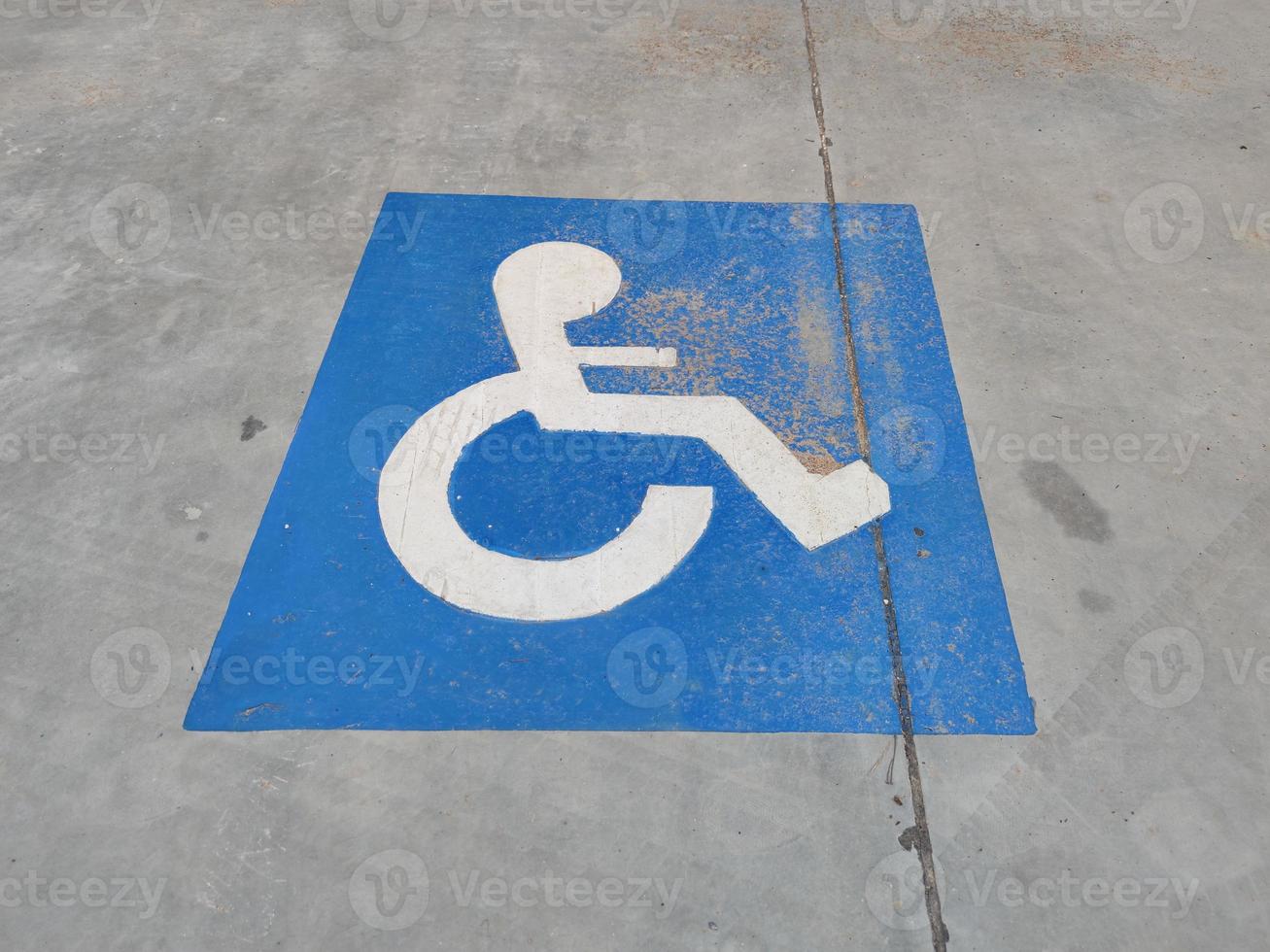 panneau bleu sur l'asphalte sur le stationnement pour personnes handicapées photo