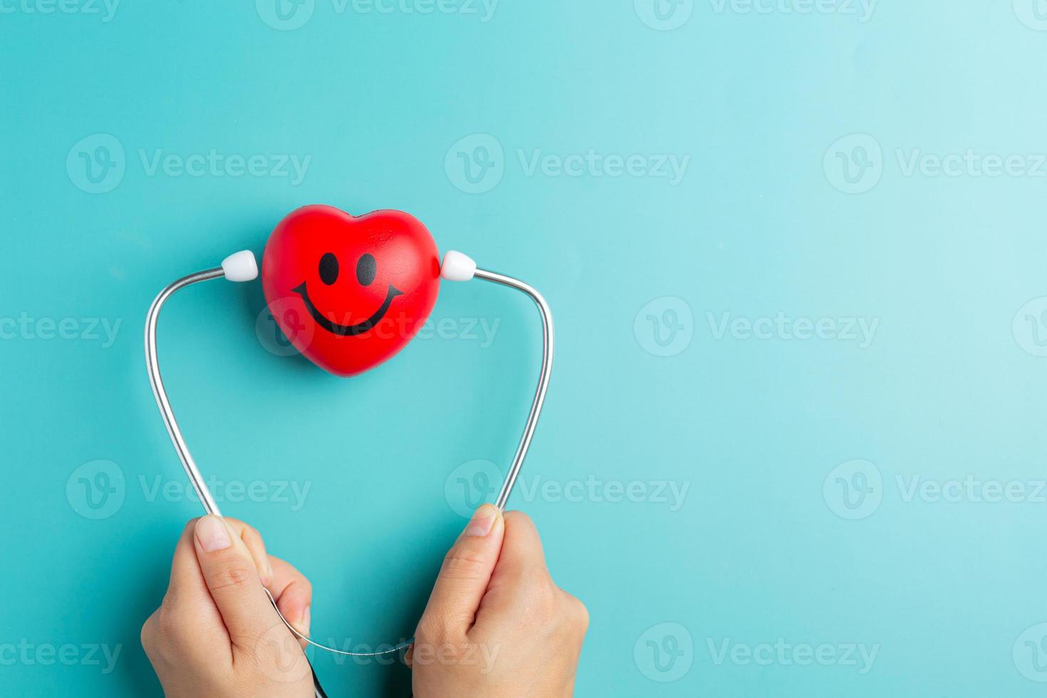 coeur rouge et stéthoscope sur fond bleu pensant la journée du pharmacien photo