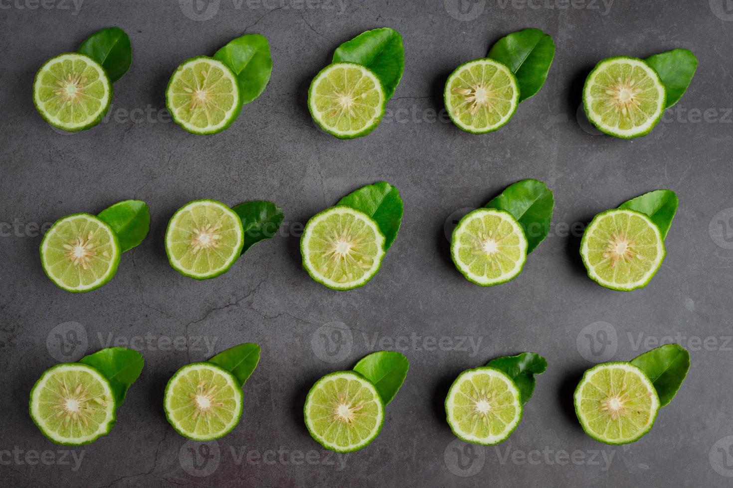 Moitiés de lime kaffir disposées sur un fond noir photo